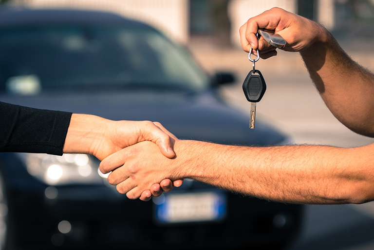 People shaking hands, one person is holding car keys